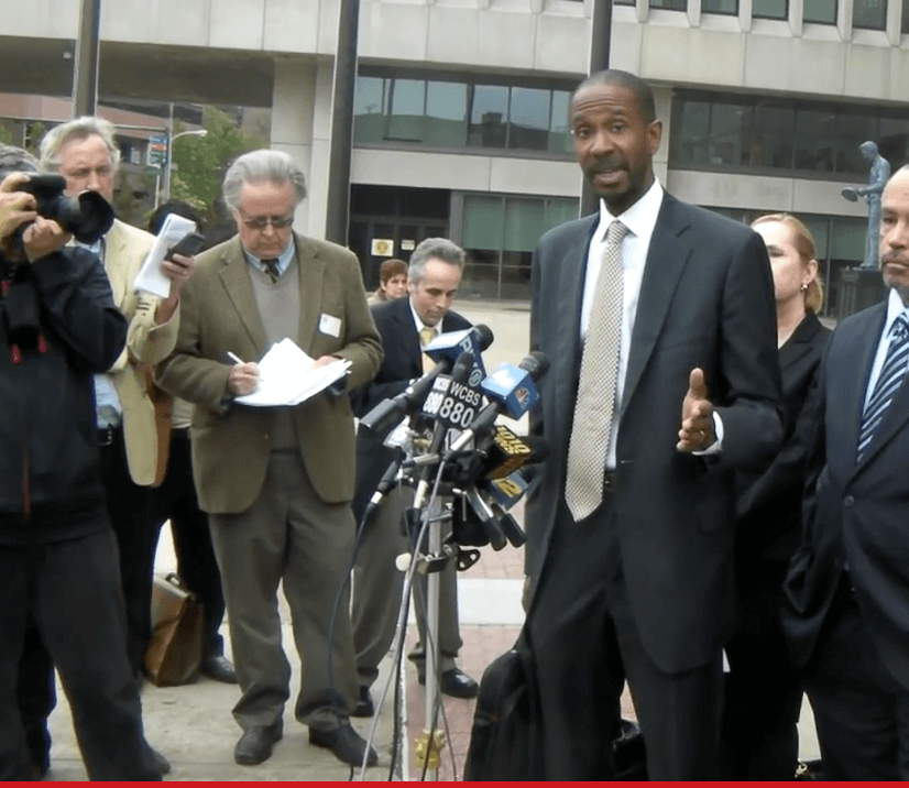 A Lawyer talking in the press meet surrounded by people